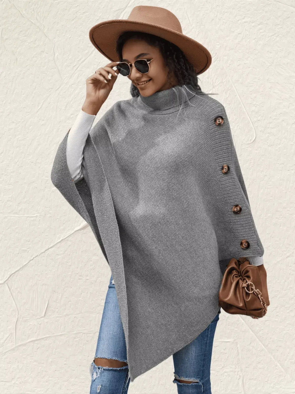 Gray buttoned poncho with brown side buttons, layered over a white knit top