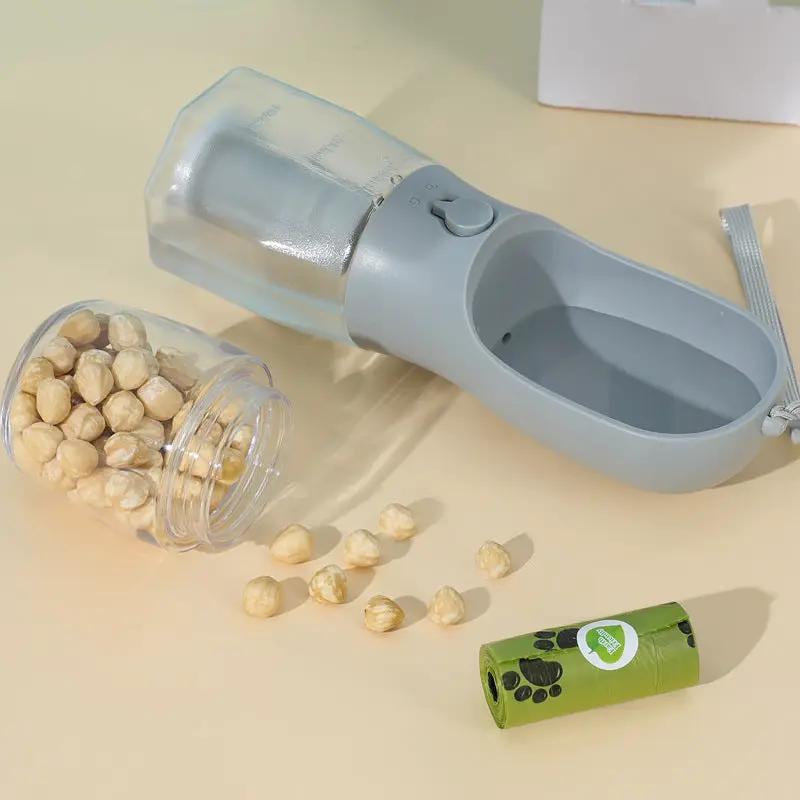 AdTec three-in-one portable dog water cup with bottle and gray bowl; green paw-print treat container beside.
