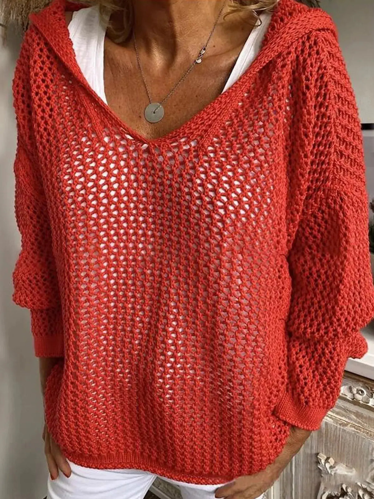 Openwork red knit hooded beach cover-up with long sleeves over white top
