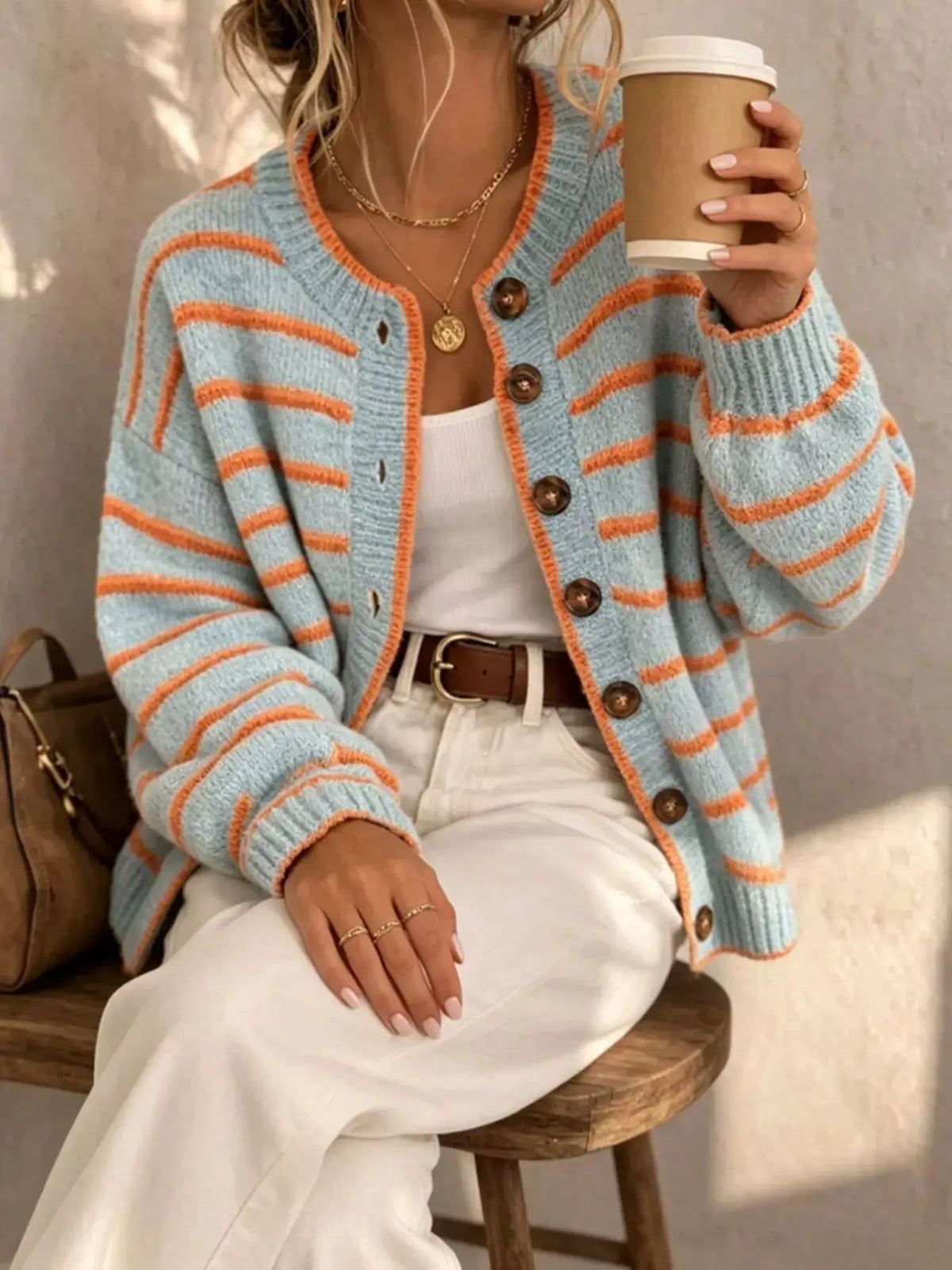 Striped knit cardigan with light blue base and orange stripes, brown buttons