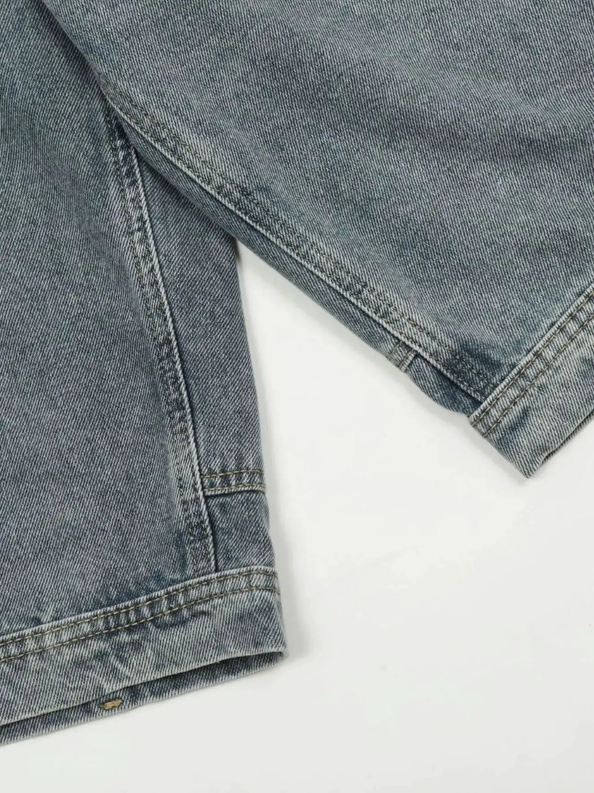 Men's washed blue denim shorts with rolled cuffs and visible stitching