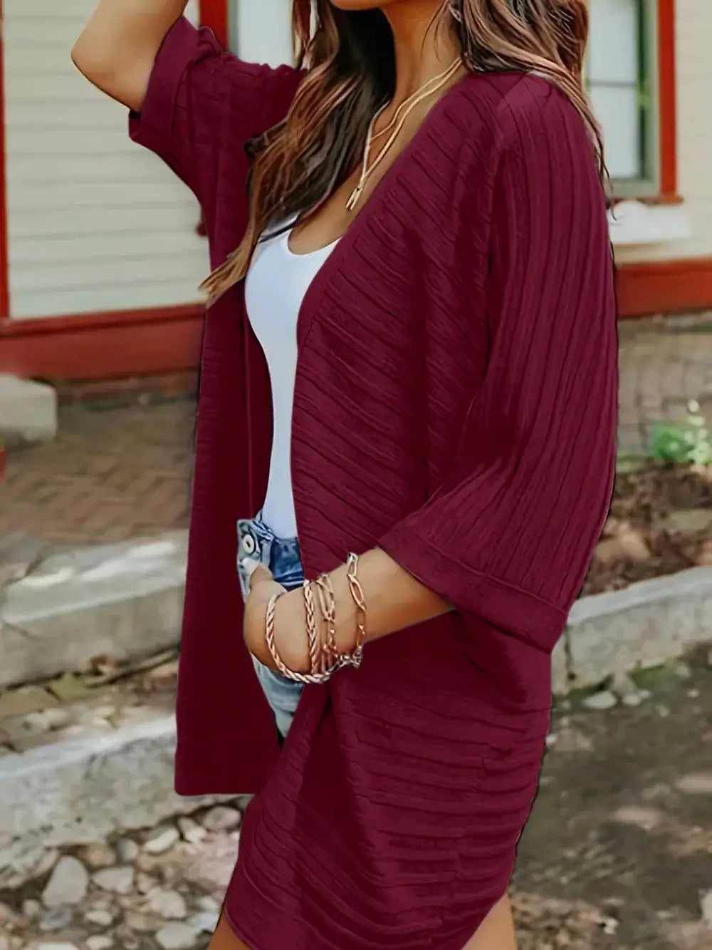 Maroon striped open-front knit acrylic cardigan worn over a white tank top