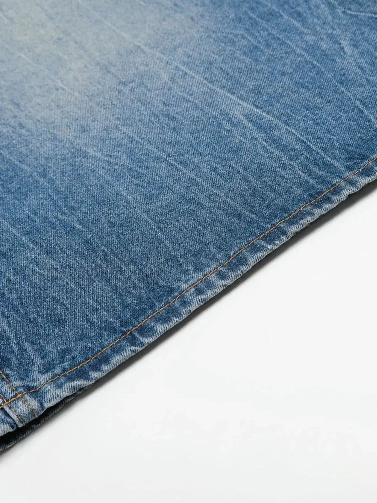 Men's relaxed-fit wide-leg washed cotton denim shorts; blue denim fabric with visible tan stitching at hem.