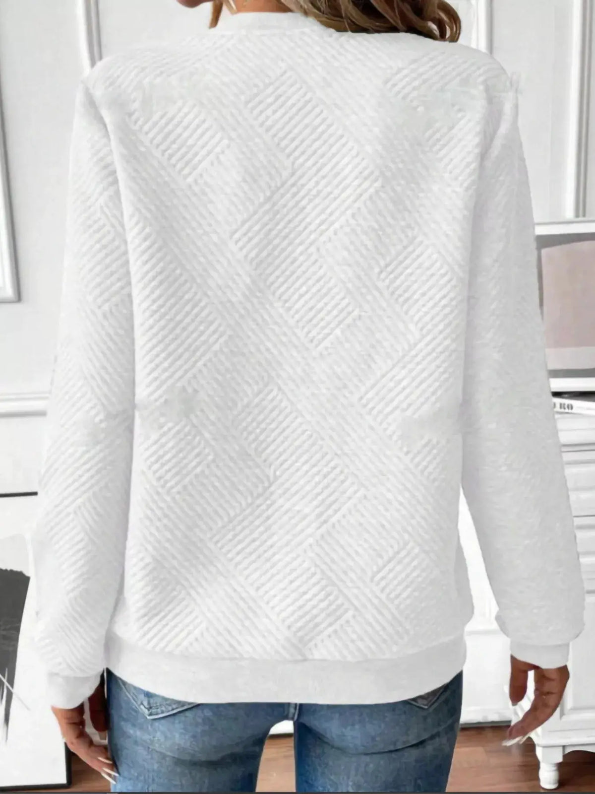 Textured white quarter-zip sweatshirt with diagonal quilting, back view on model.