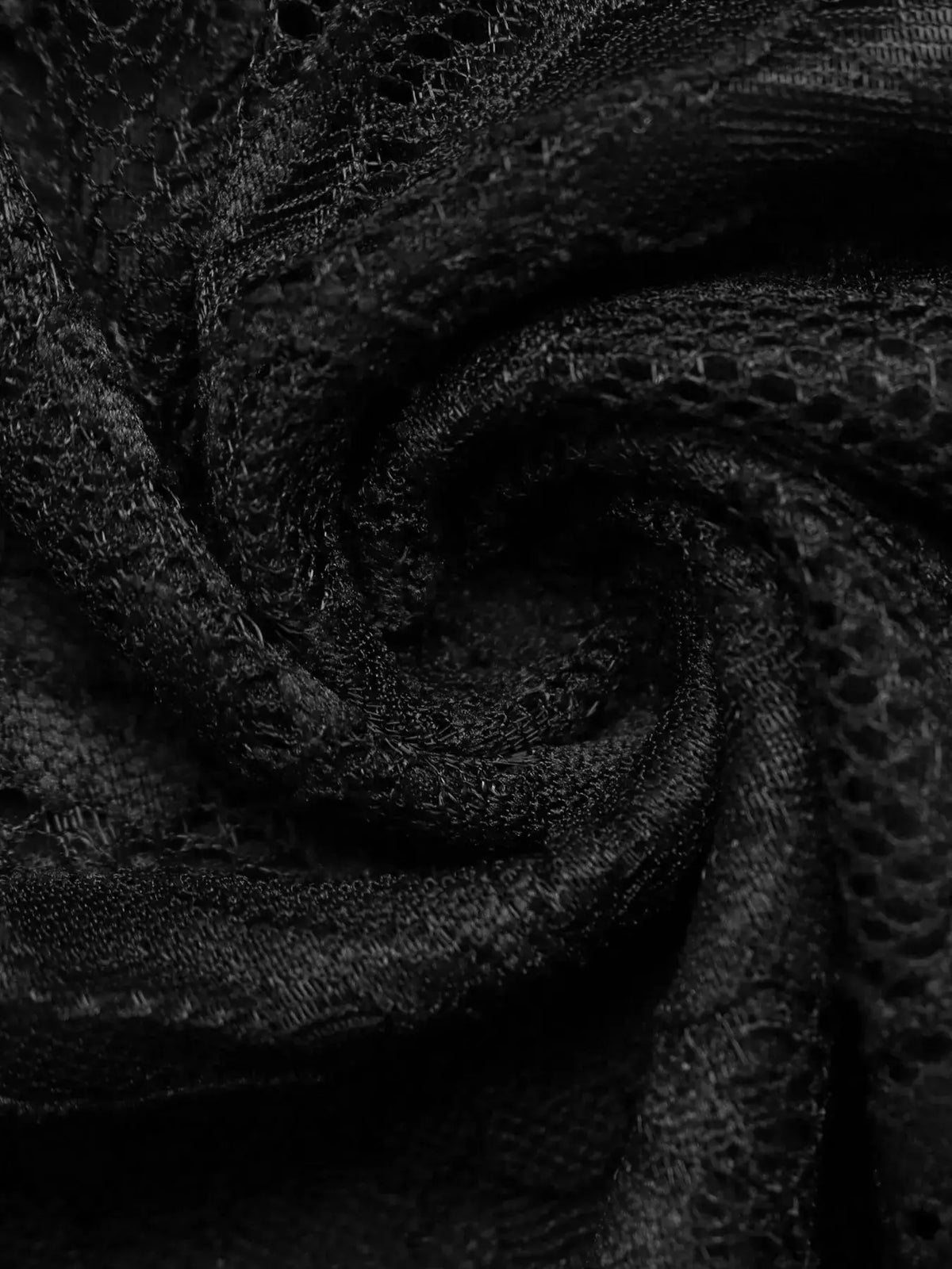 Lace fabric close-up in black with intricate netting texture