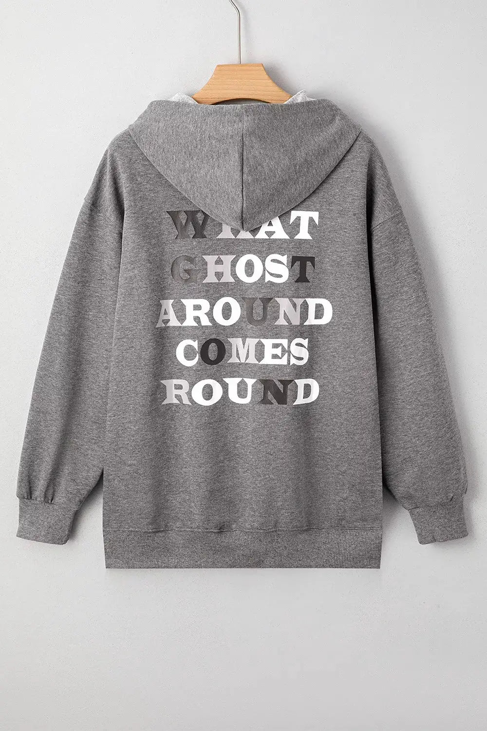 Oversized gray hoodie with white back print reading WHAT GHOST AROUND COMES ROUND