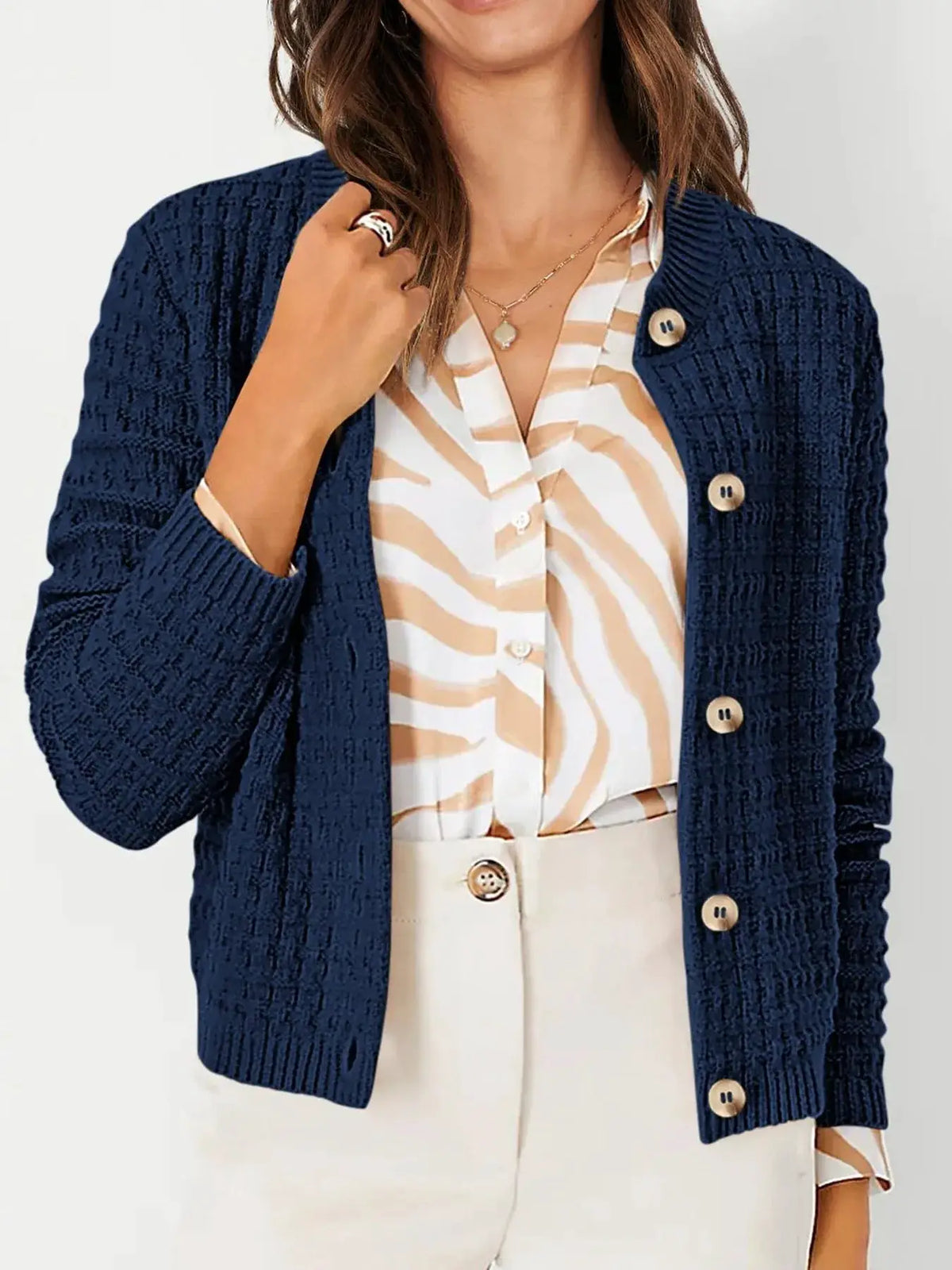 Textured stretchy knit button-front cardigan in navy, worn over a beige zebra-print blouse.