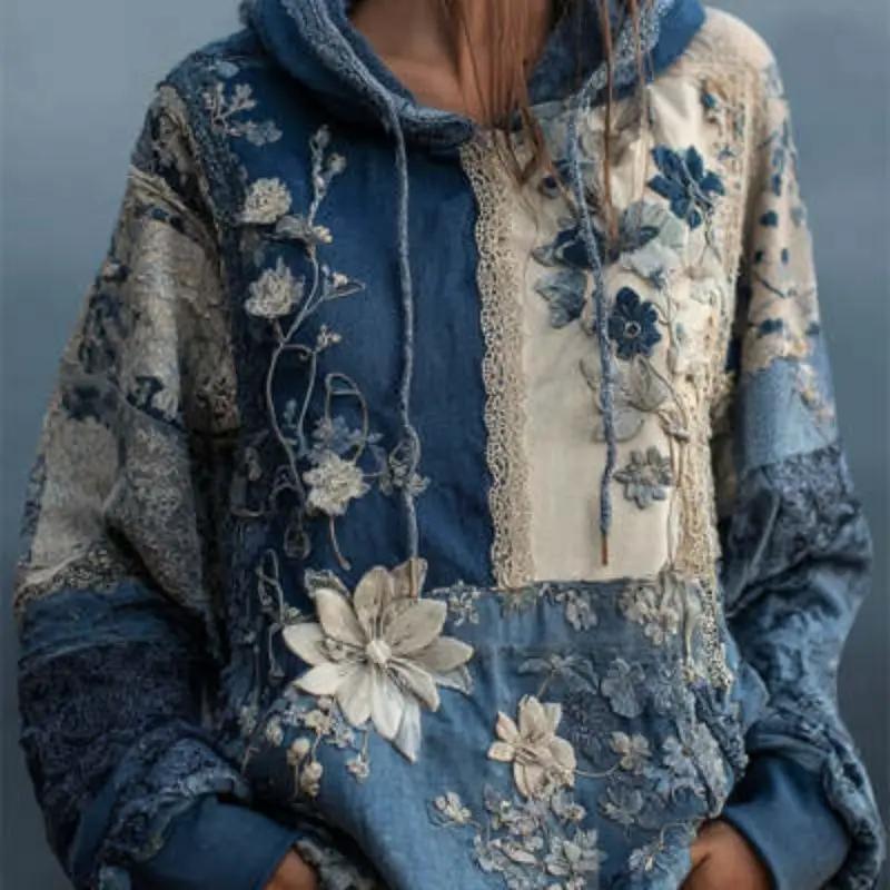 Women's plus-size printed relaxed-fit pullover hoodie in blue patchwork with cream floral embroidery.