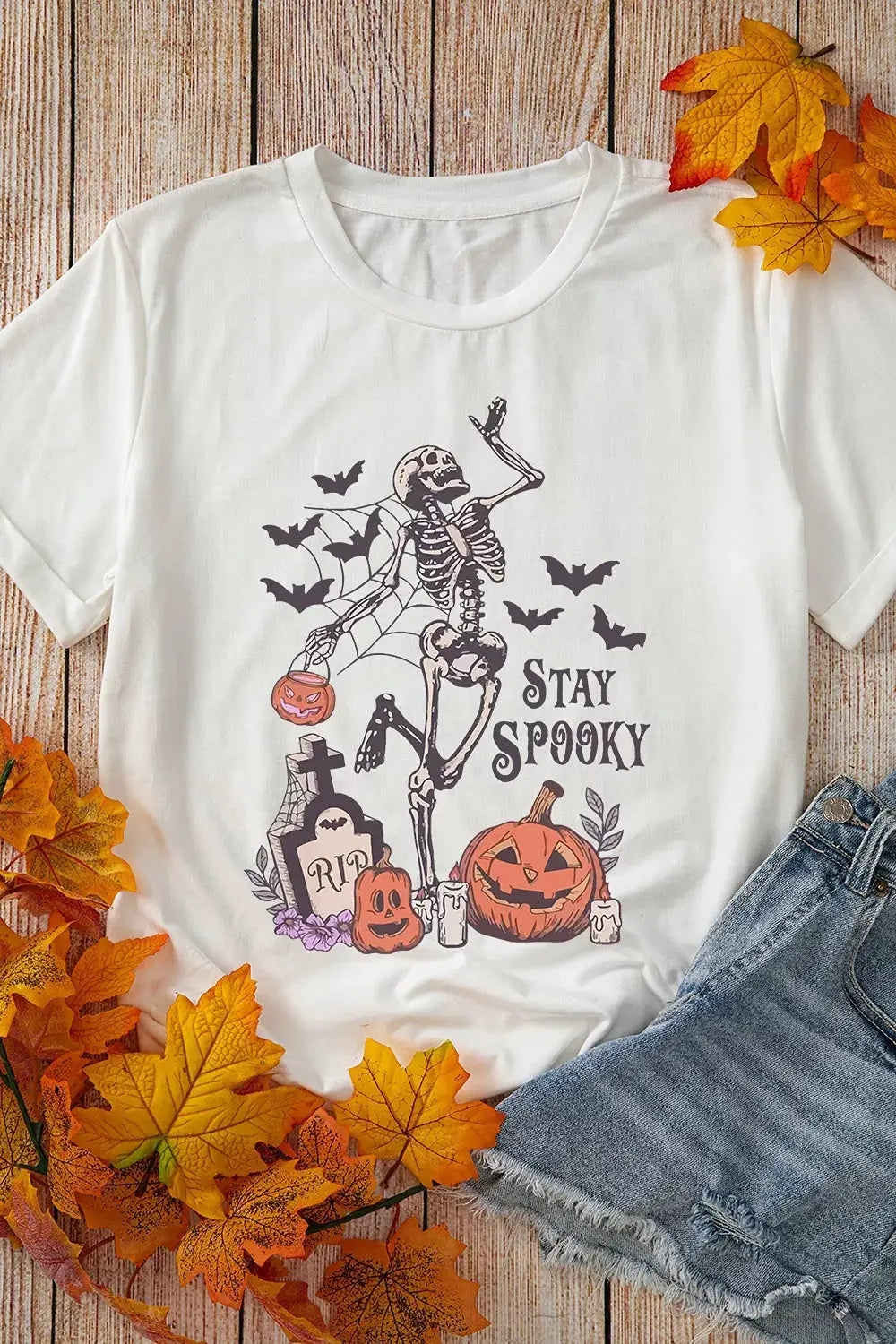 Plus-size white Halloween graphic T-shirt with skeleton, pumpkins, bats and Stay Spooky text