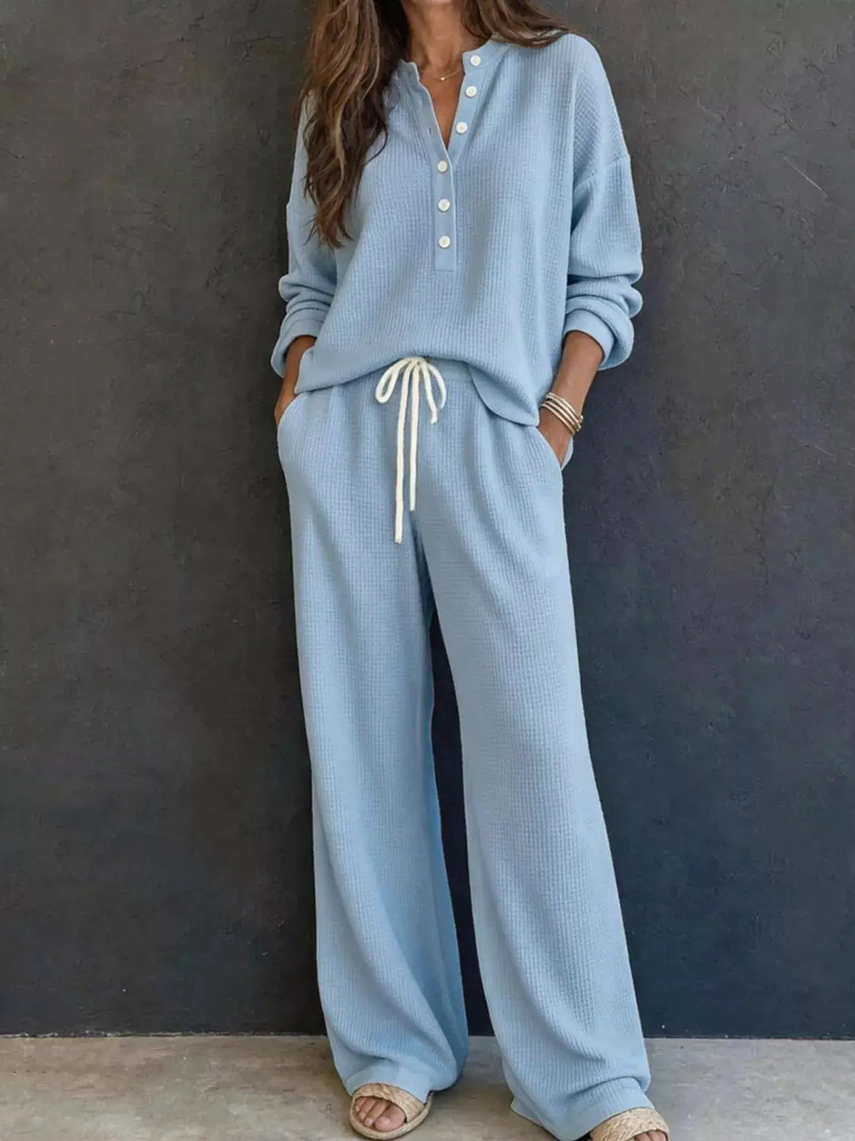 Waffle-knit henley top and matching wide-leg pants set in light blue; button-front top with drawstring pants.