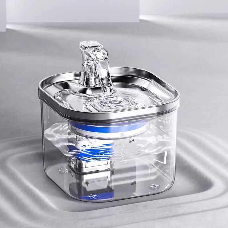Pet water fountain for automatic circulation; transparent reservoir with blue ring and stainless steel spout.