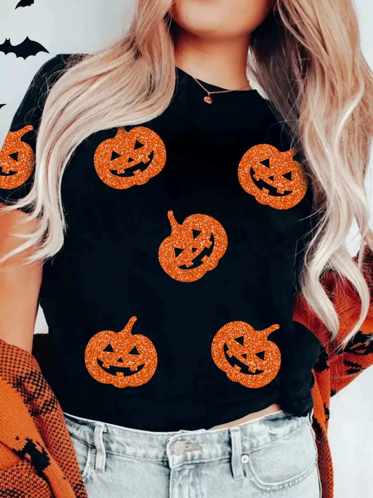 Glittering Pumpkin Face Crewneck Halloween T‑Shirt; black fabric with five orange glitter jack-o-lanterns