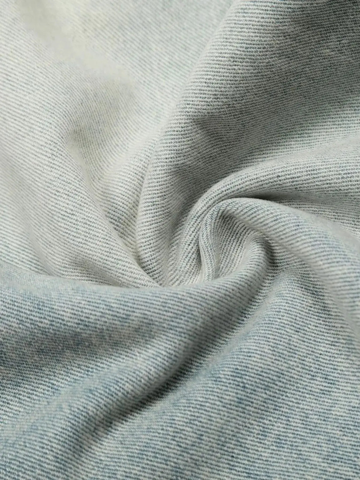 Mens wide-leg denim shorts in light blue cotton denim fabric, close-up.
