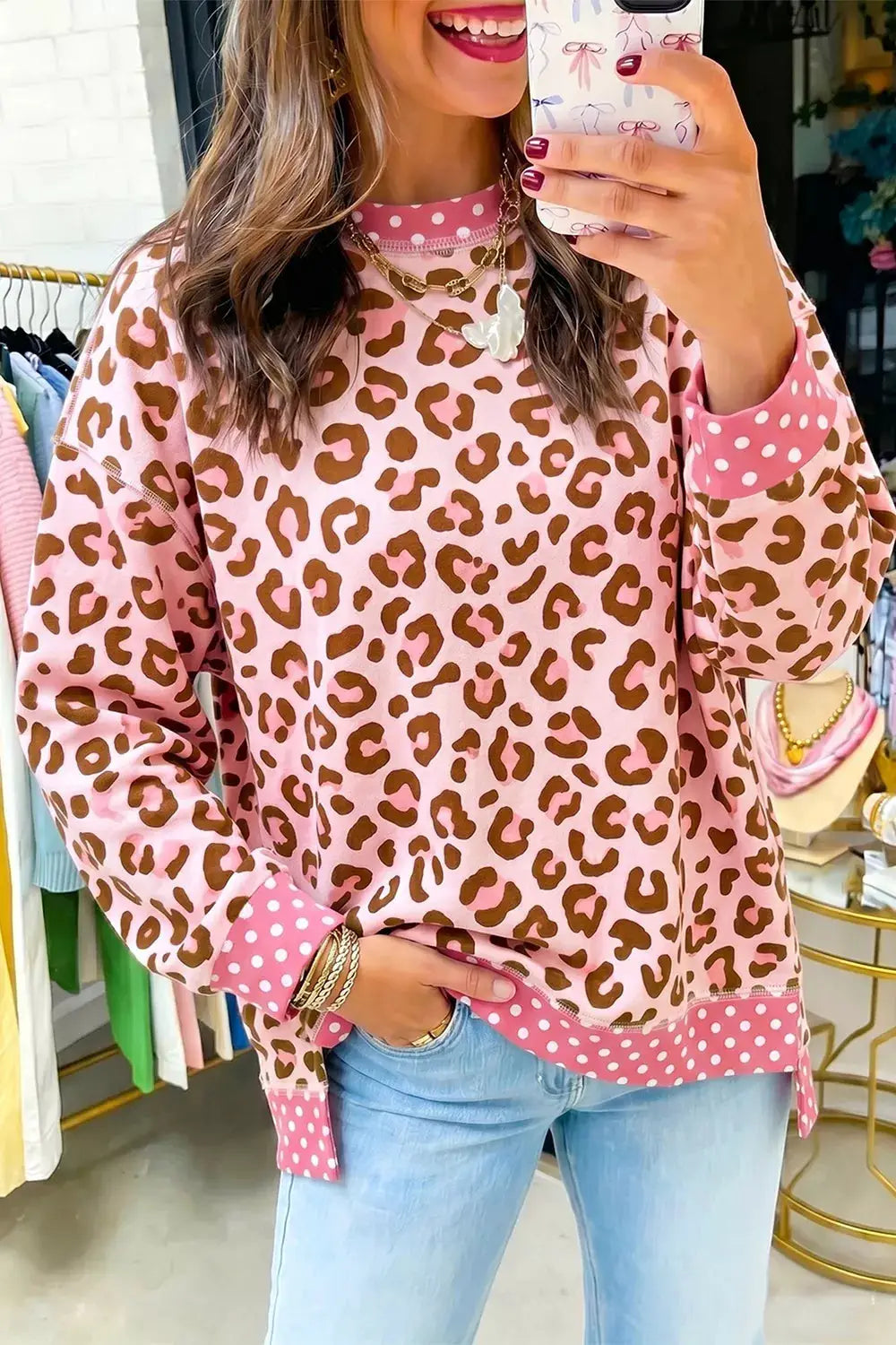 Polka dot contrast trim leopard round-neck sweatshirt in pink with brown leopard print and pink polka-dot cuffs.