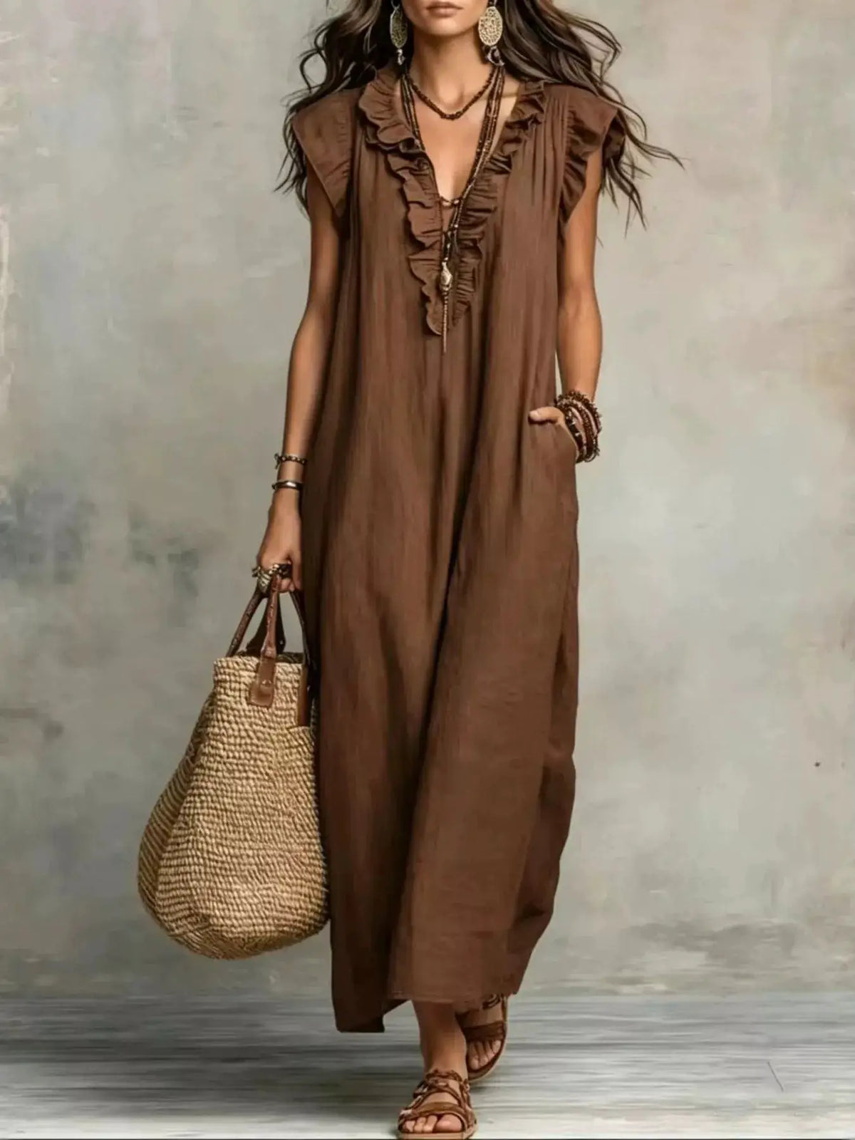Trendsi plus-size brown maxi dress with ruffled V-neck cap-sleeve, worn by model with straw tote
