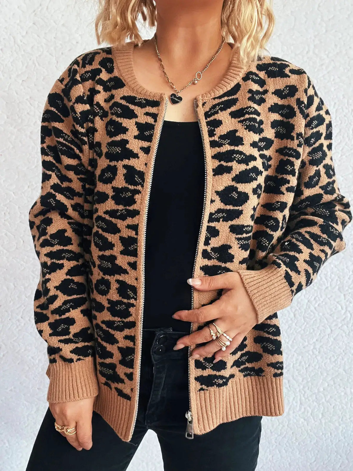 Leopard print zip-up cardigan with long sleeves, tan and black knit, worn over black top