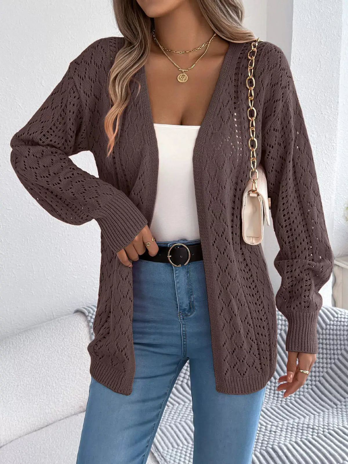Openwork long-sleeve cardigan in taupe knit, open-front styling worn over a white top