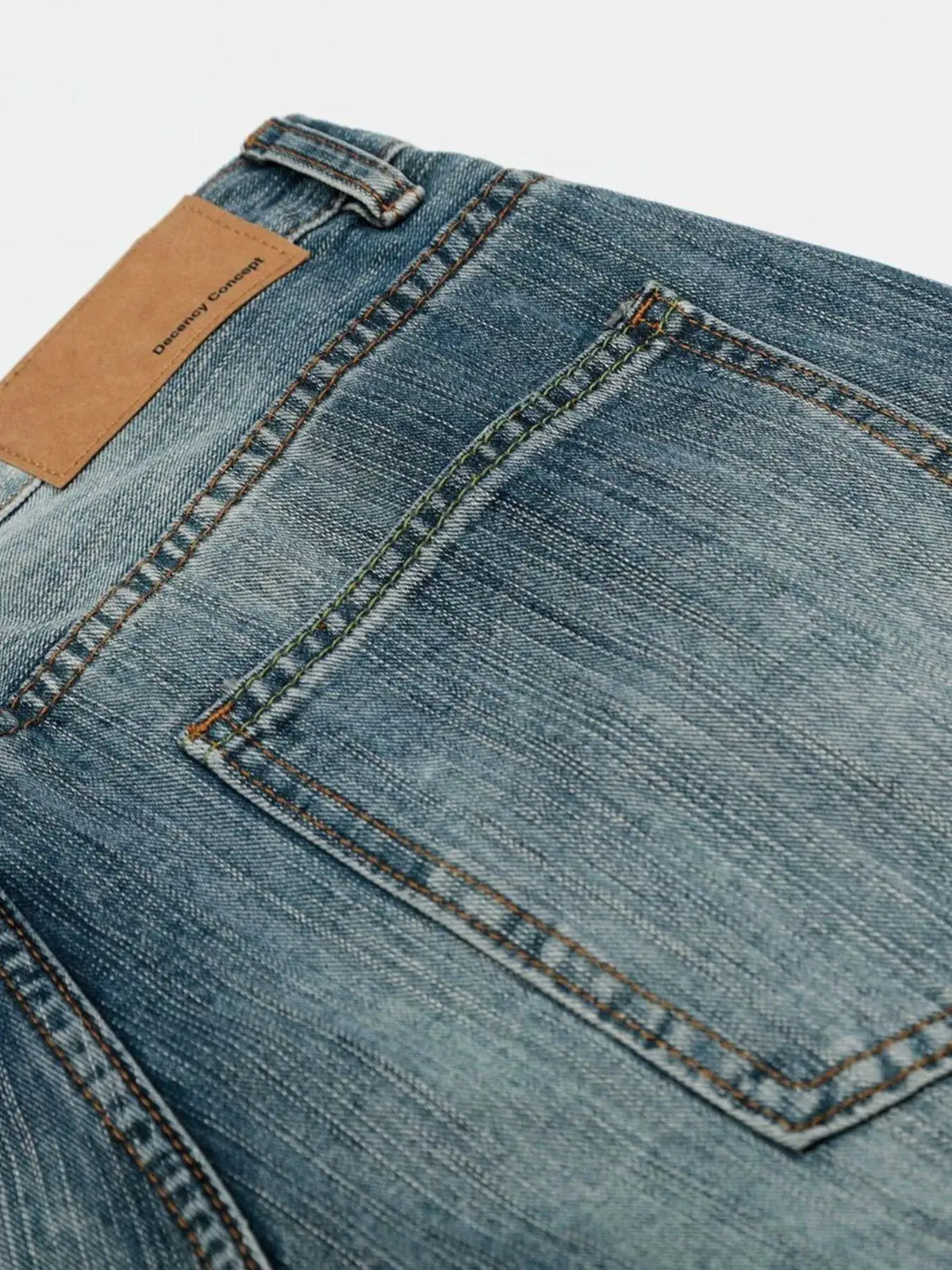 Mens wide-leg washed denim shorts with tan leather patch and double-stitched back pockets