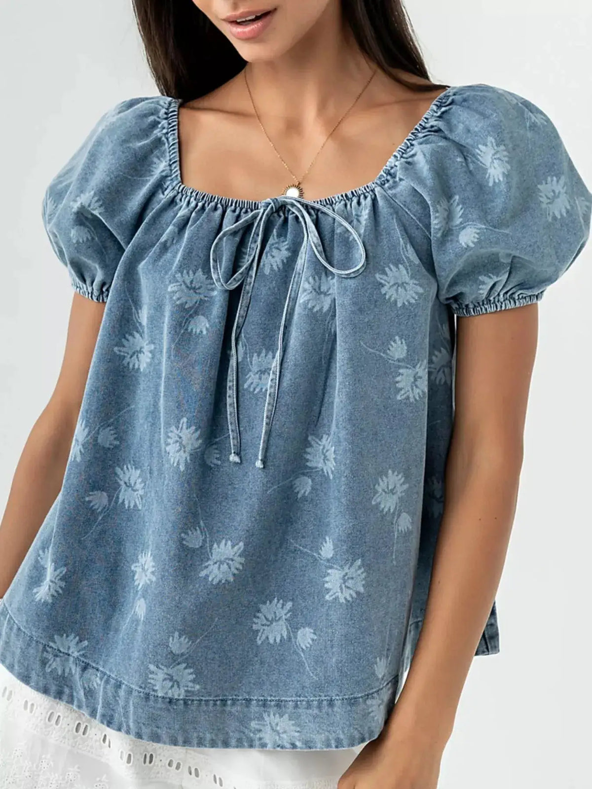 Women’s floral print puff-sleeve denim-cotton blend top with tie-front neckline in blue.