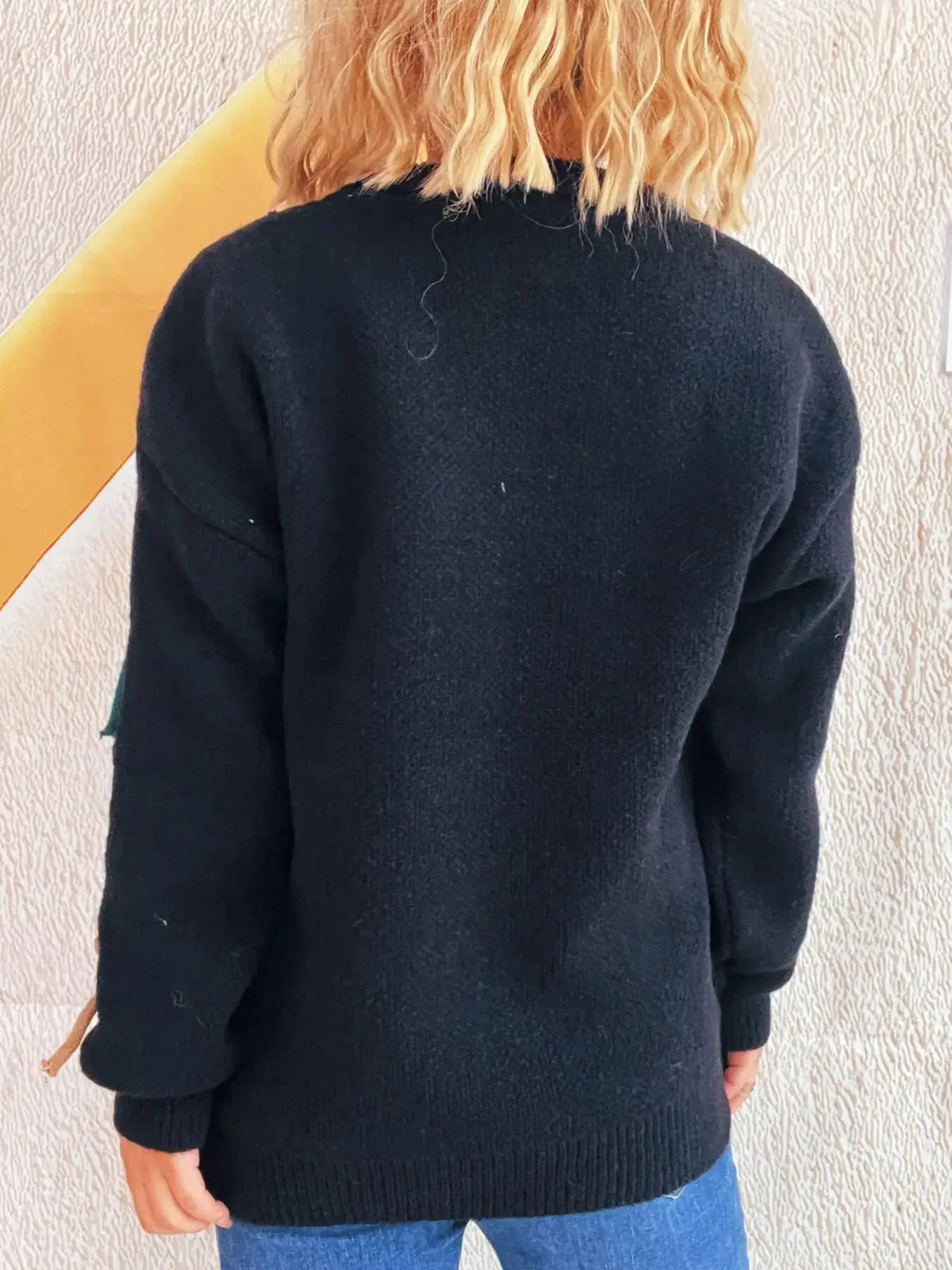 Women's black round-neck knit pullover sweater, back view.