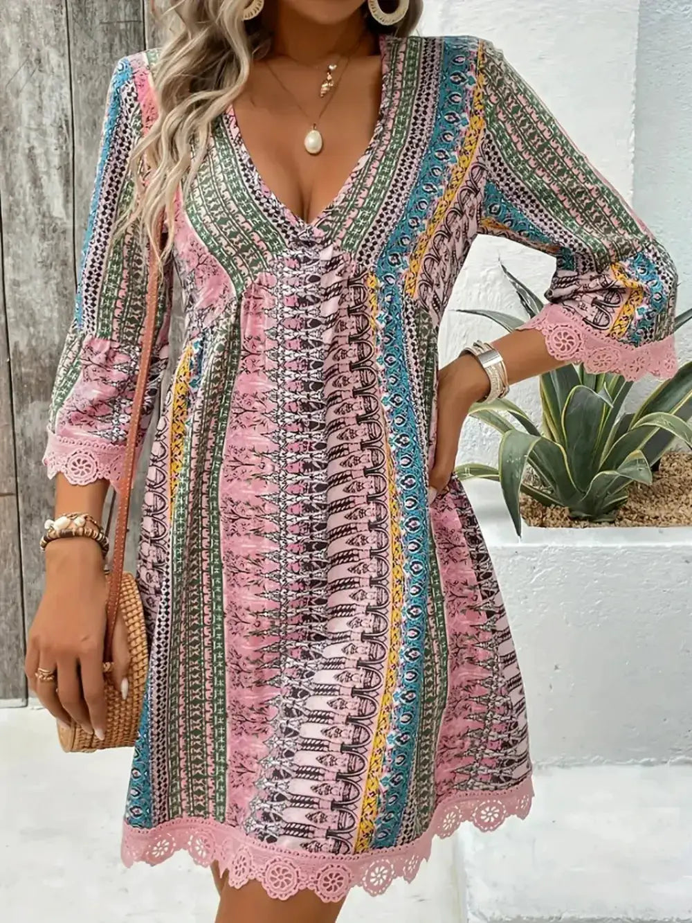 Lace-trimmed printed V-neck dress with 3/4 sleeves, pink lace hem, multicolor pattern.