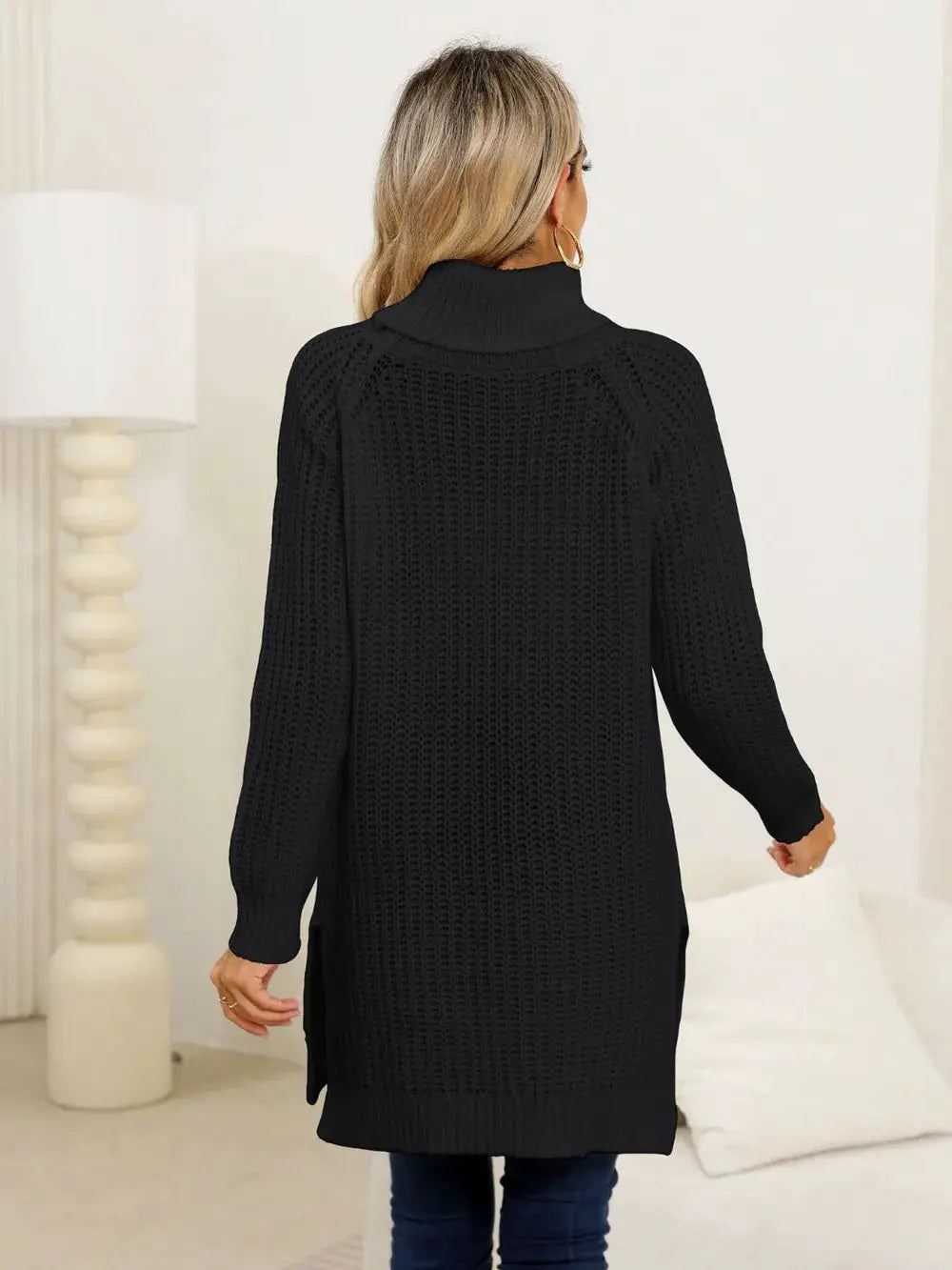 Womens black slit turtleneck long-sleeve stretchy knit pullover sweater, back view with side slits and ribbed cuffs.