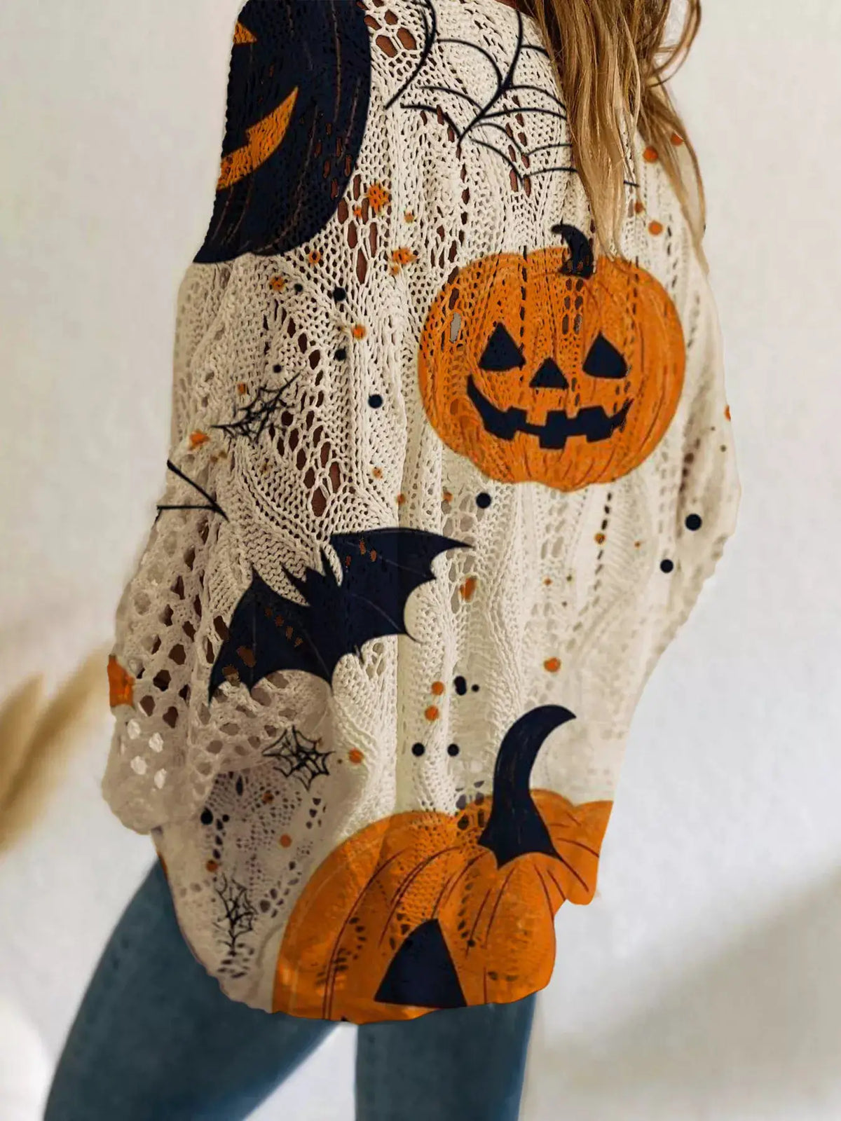 Plus-size Halloween pumpkin loose-knit cover-up in cream knit with orange pumpkins and black bats