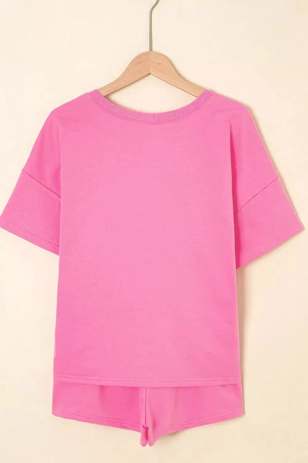 Pink short-sleeve tee with matching drawstring shorts set on a hanger by Trendsi