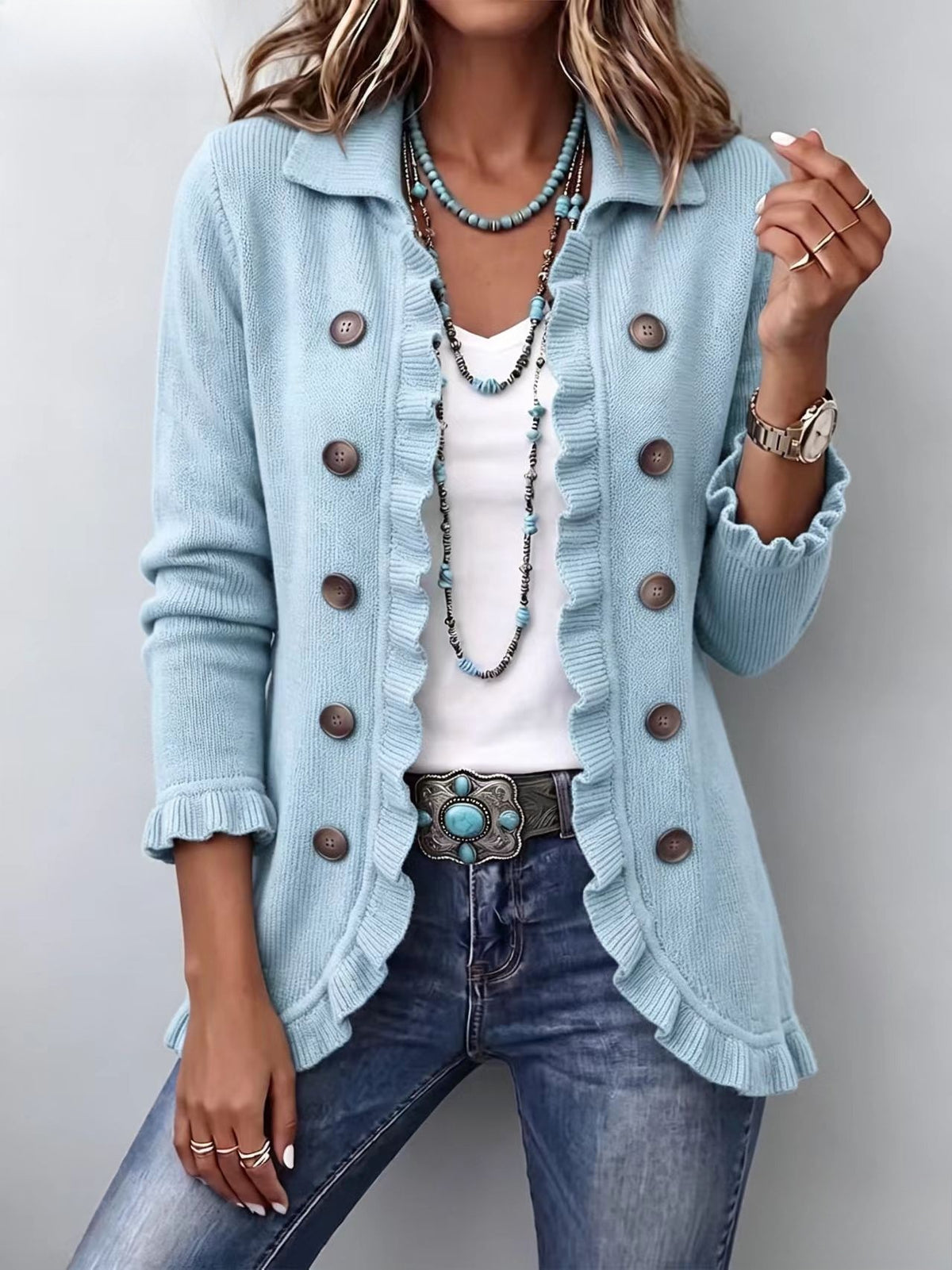 Long light-blue knit cardigan with ruffled front trim and large brown buttons.