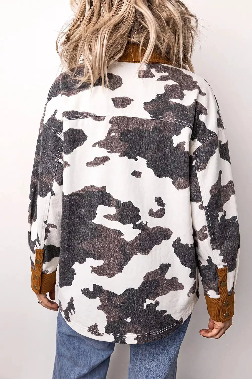 Long-sleeve denim jacket with multicolor cow-print and brown cuff accents