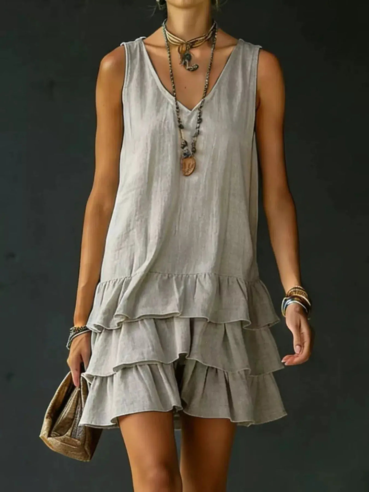 Ruffled-hem V-neck sleeveless dress, plus-size, in light gray with layered tiered skirt and flowing fabric.