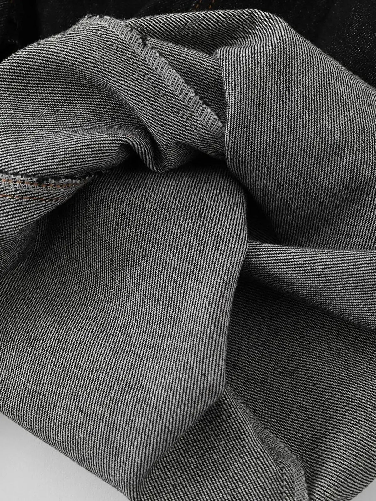 Men's wide-leg denim shorts, cotton-blend fabric; close-up of textured denim weave.