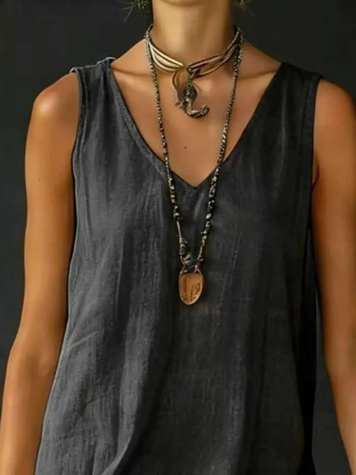 Full Size Ruffled Hem V-Neck Sleeveless Dress Plus Size in dark grey, shown with layered necklaces