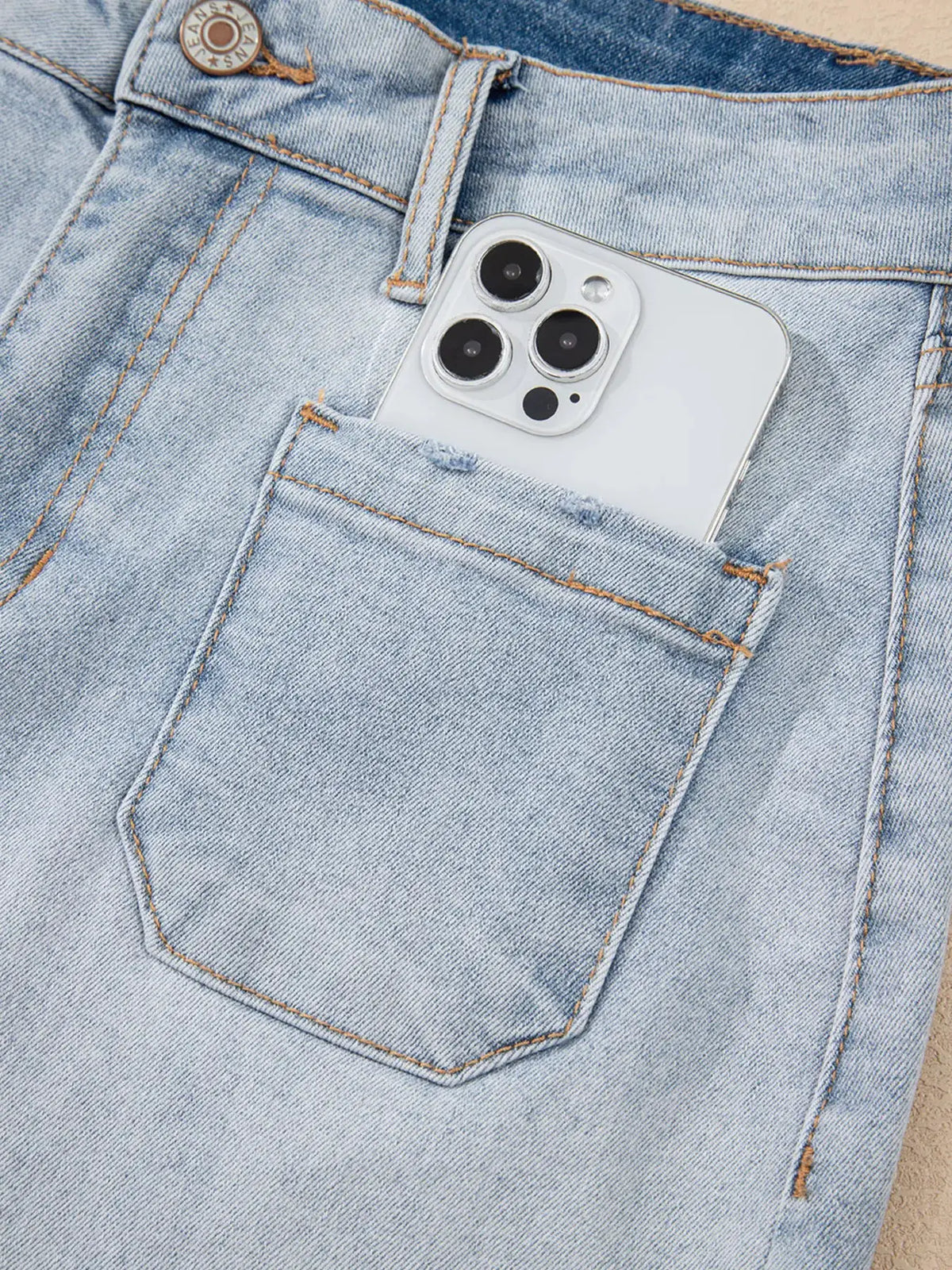 Wash High Rise Denim Shorts by Trendsi in light blue denim with a phone visible in the back pocket.