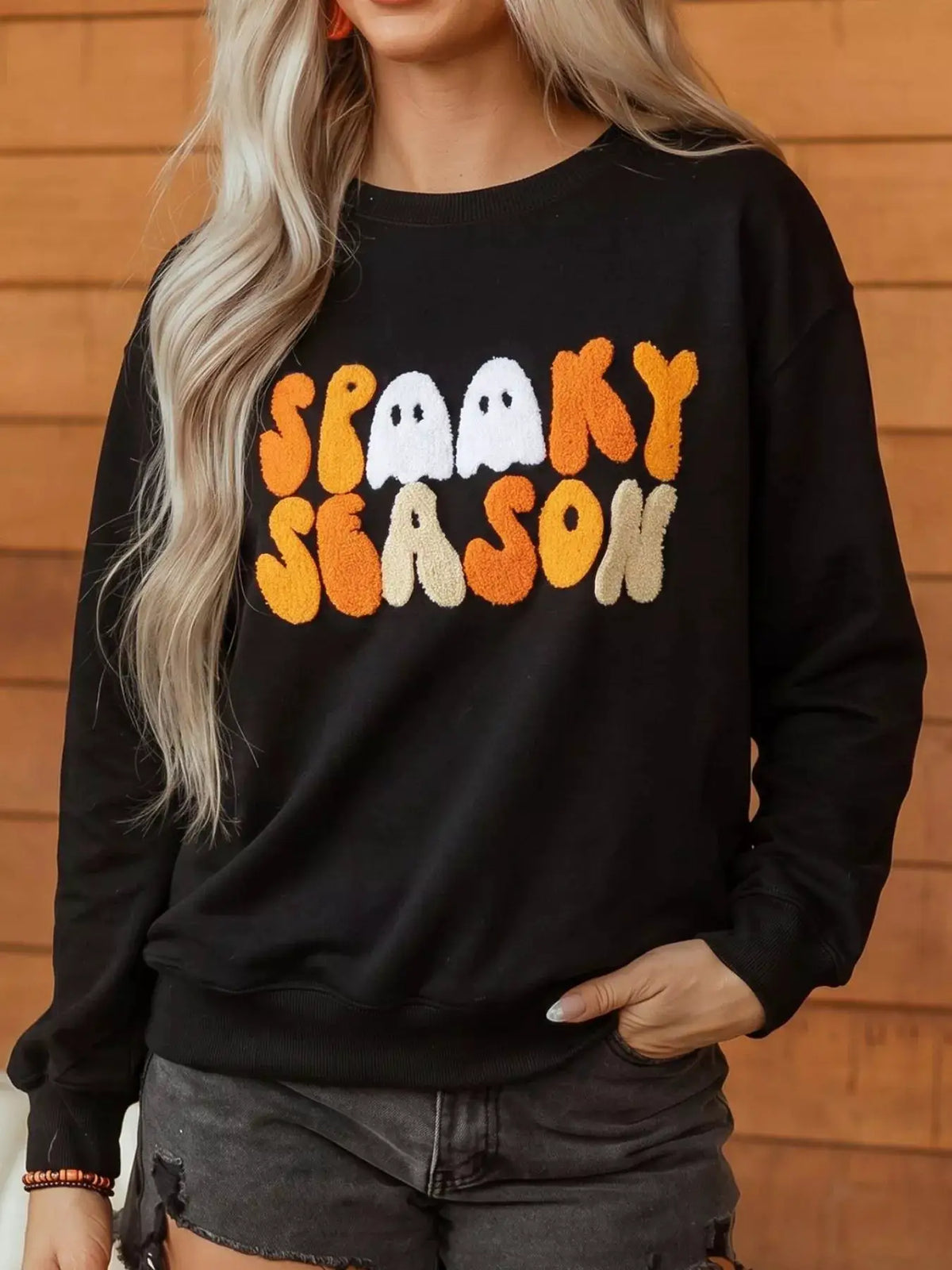 Embroidered Spooky Season long-sleeve black sweatshirt with orange and white chenille lettering