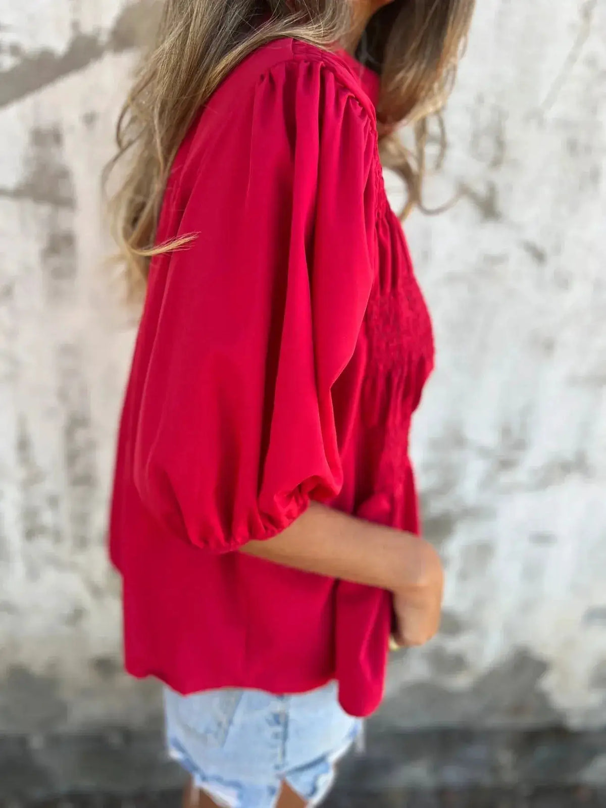 Full Size Smocked Puff Sleeve Blouse in red, side view of model wearing with light denim shorts.