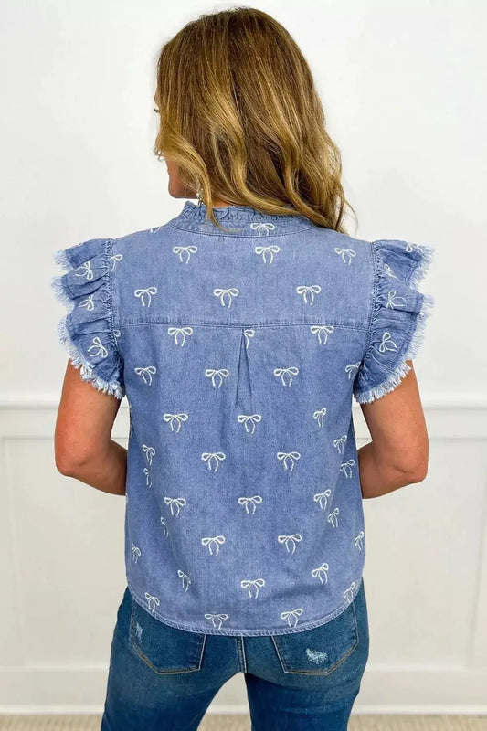 Womens light blue denim top with white bow print, frilled collar, flutter sleeves and raw hem.