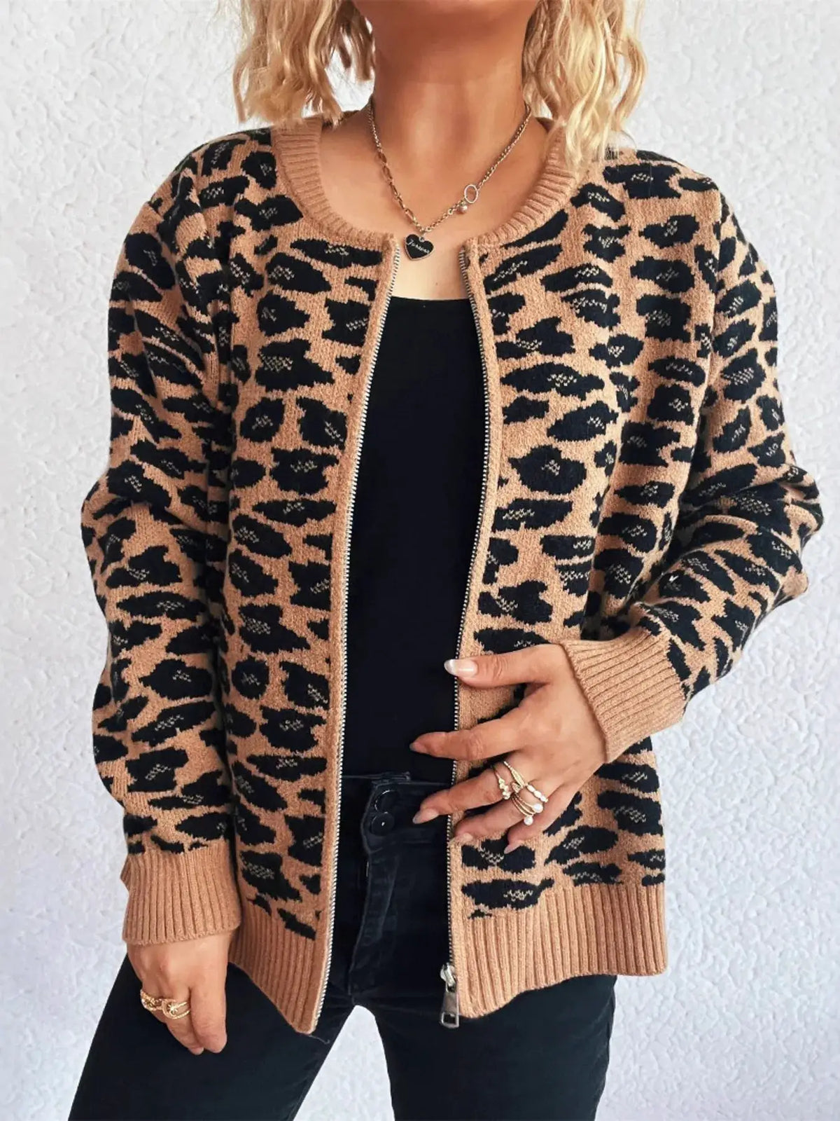 Zip-up leopard print cardigan in camel and black with ribbed cuffs and hem, worn over a black top