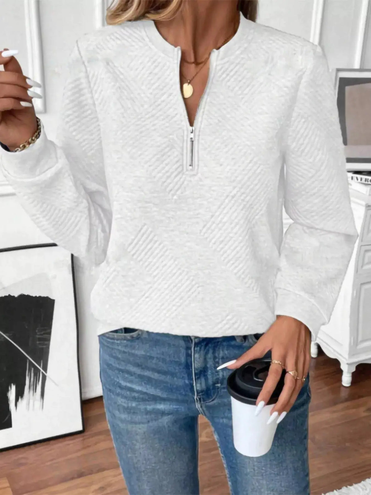 Textured white quarter-zip sweatshirt, long-sleeve knit top.