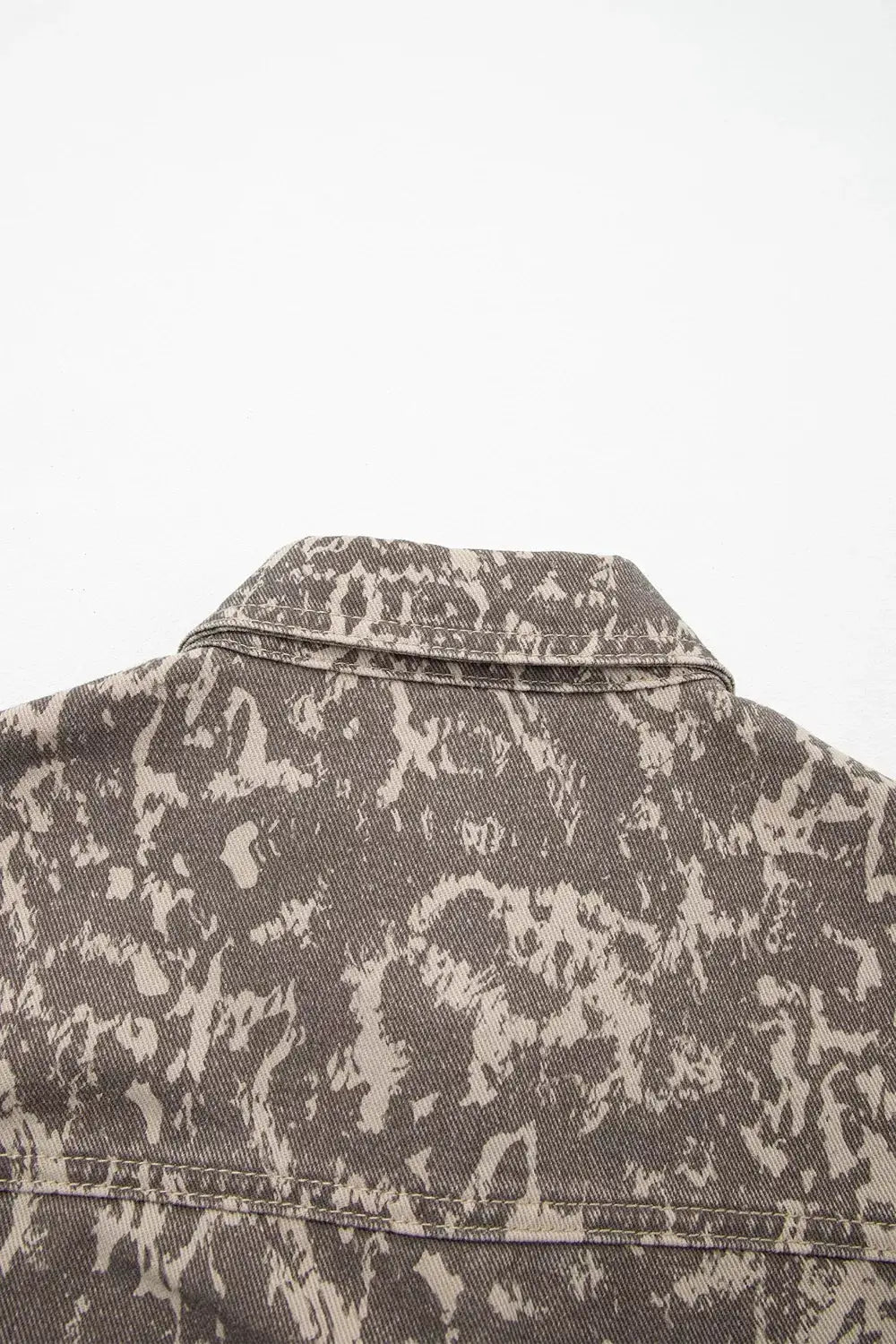 Abstract print denim jacket; long sleeves with raw hem, back view in gray-taupe denim