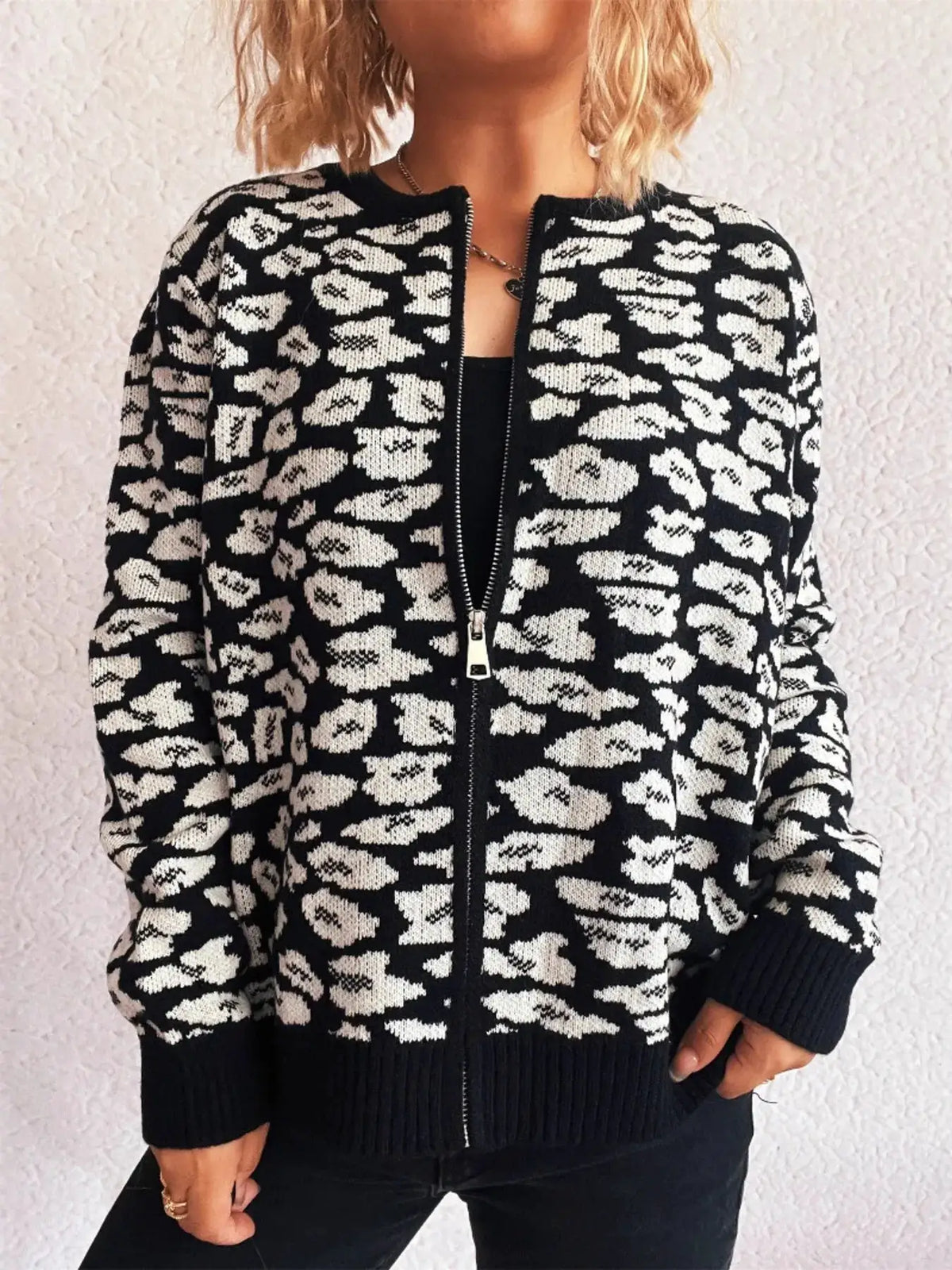 Zip-up long-sleeve cardigan in black-and-white animal print with front zipper and ribbed cuffs and hem.