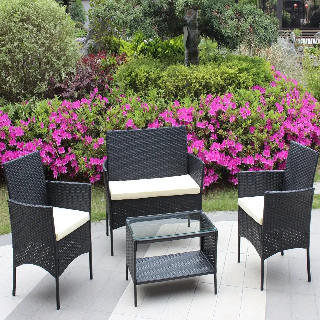 4-piece black rattan patio furniture set with beige cushions and glass-top coffee table