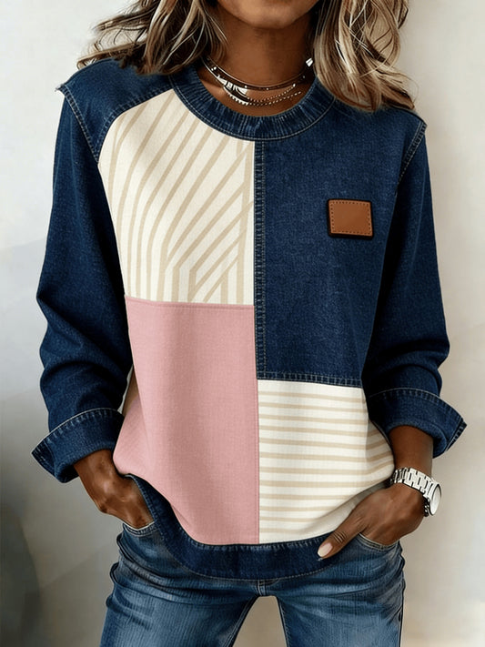 Women's patchwork denim sweatshirt with beige striped and pink color-block panels and a brown leather patch.