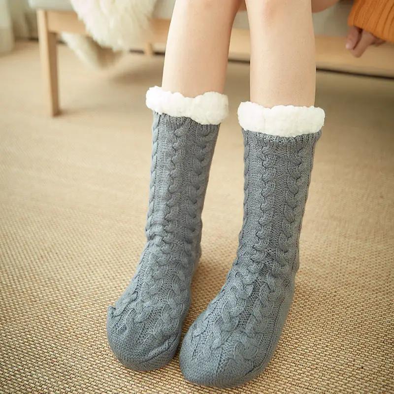 Pair of knee-high gray knit socks with white fleece cuffs, cozy cable-knit texture and soft lining for chilly days