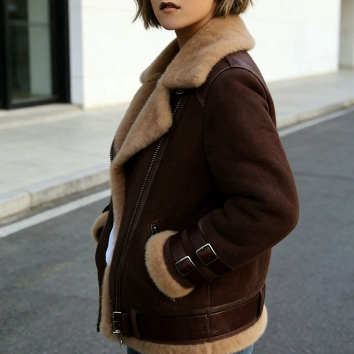 Women's brown shearling jacket with tan faux fur trim, zip front, and belt details for a rugged autumn look