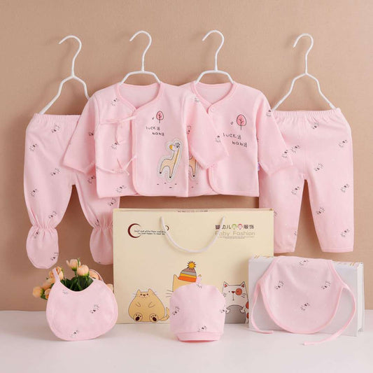 Seven-piece pink newborn clothing set on hangers, including jackets, pants, hat, and bib.