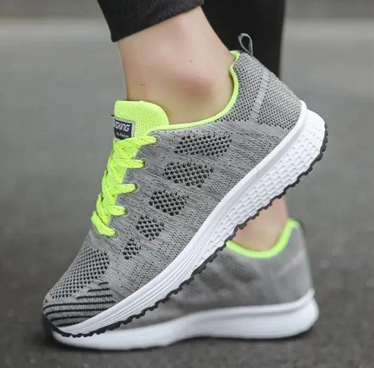 Women’s sports sneakers by AdTec, grey knit mesh upper with neon lime laces and white midsole, black outsole (pair)