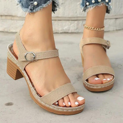 Open-toe buckle-strap chunky-heel sandals with textured beige straps.