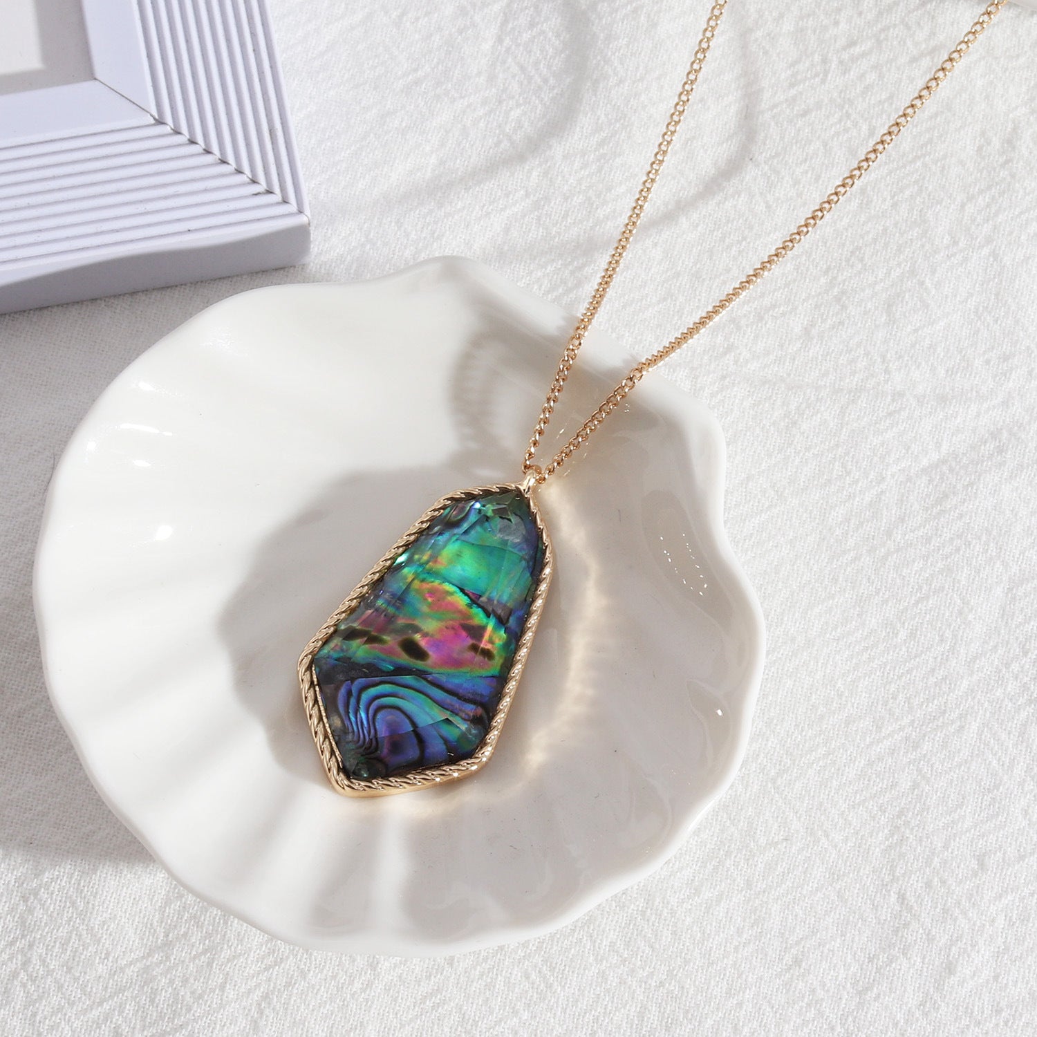 Collier en résine à longues facettes et coquille d'ormeau
