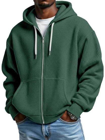Men's green zip-up hoodie with kangaroo pockets, ribbed cuffs and hood drawstrings, waffle-knit texture.